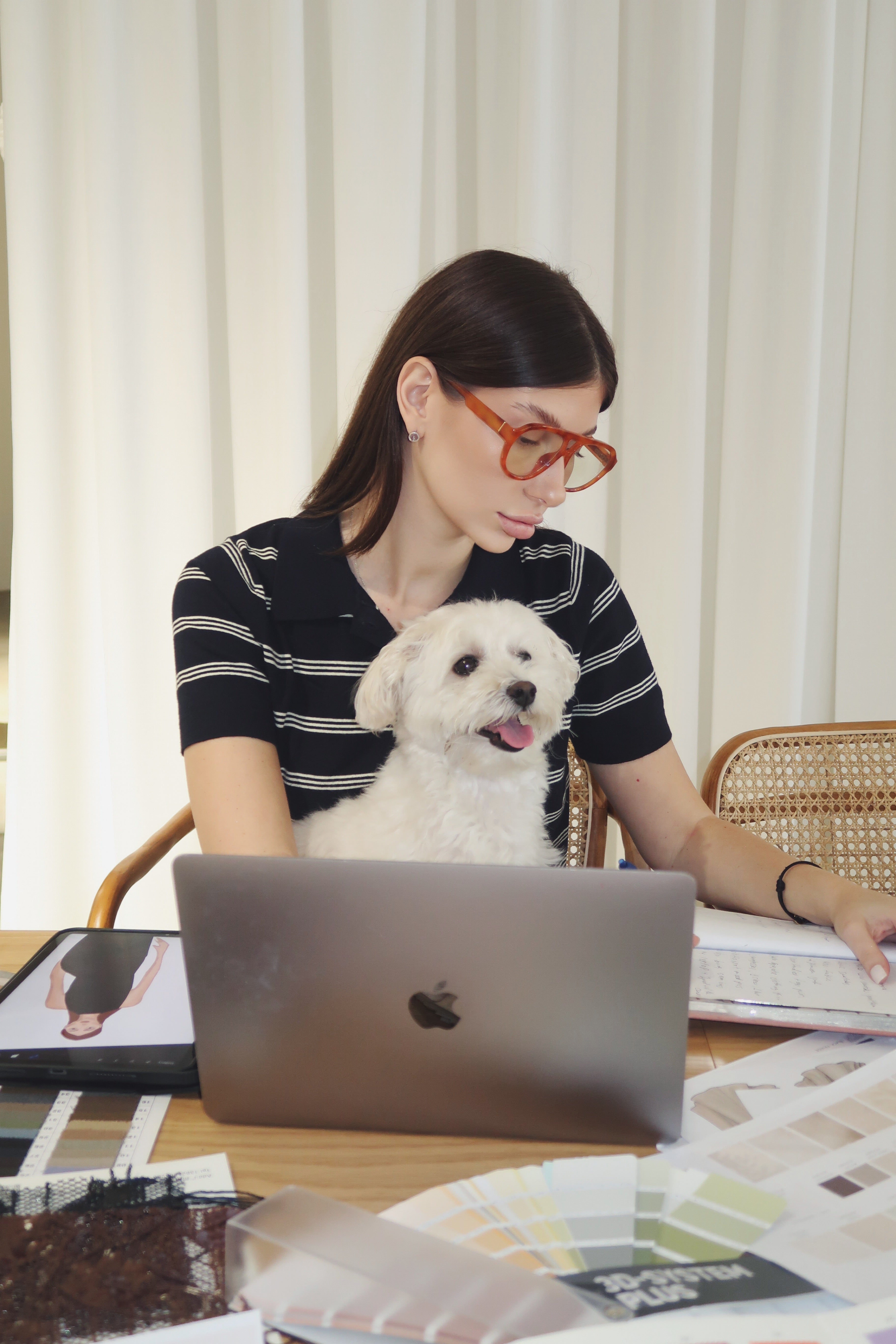 Nini working at her studio table with her dog