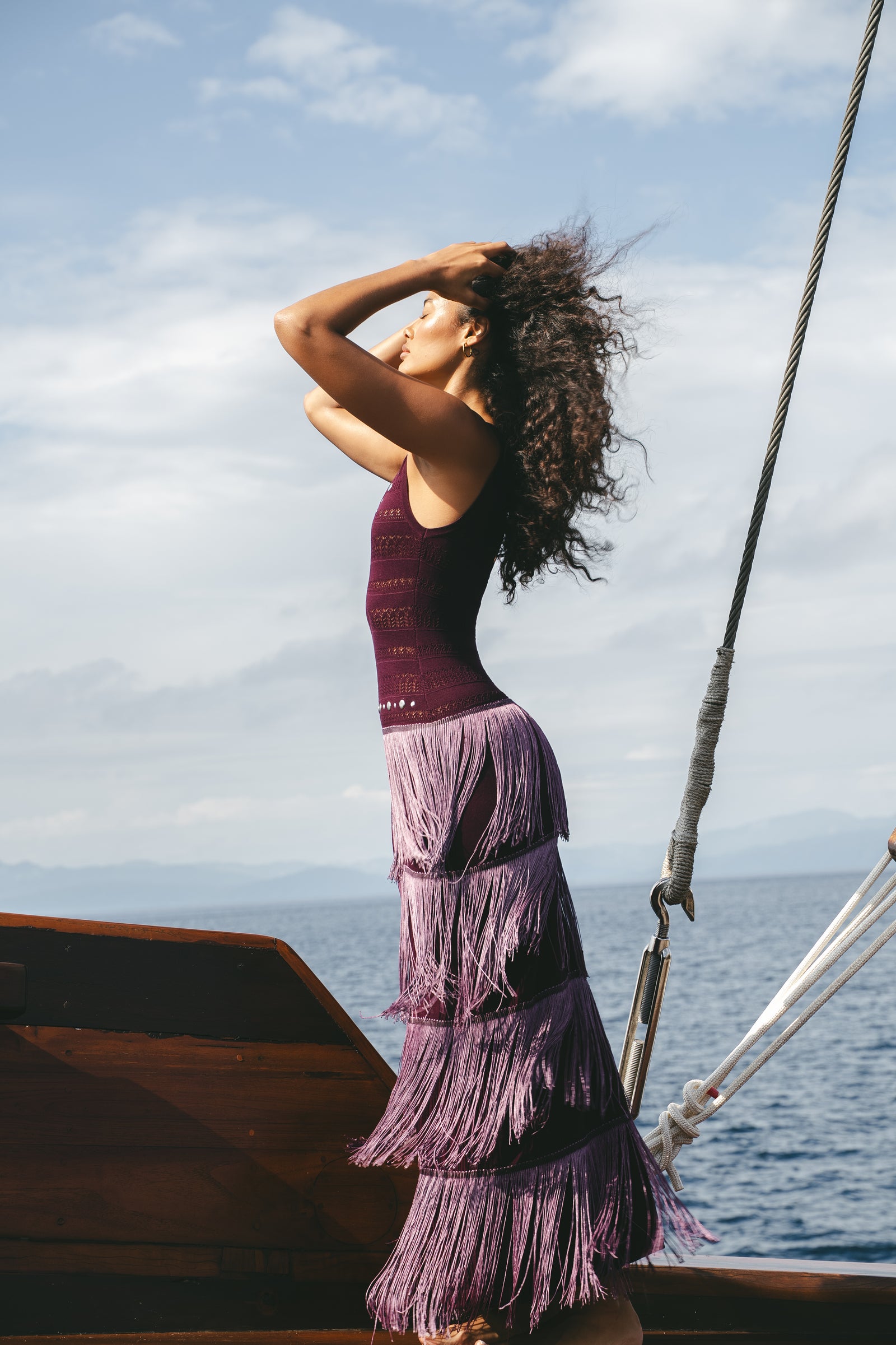 Profile view of the mulberry Fringe Knit Maxi Dress showing the full layered fringe silhouette
