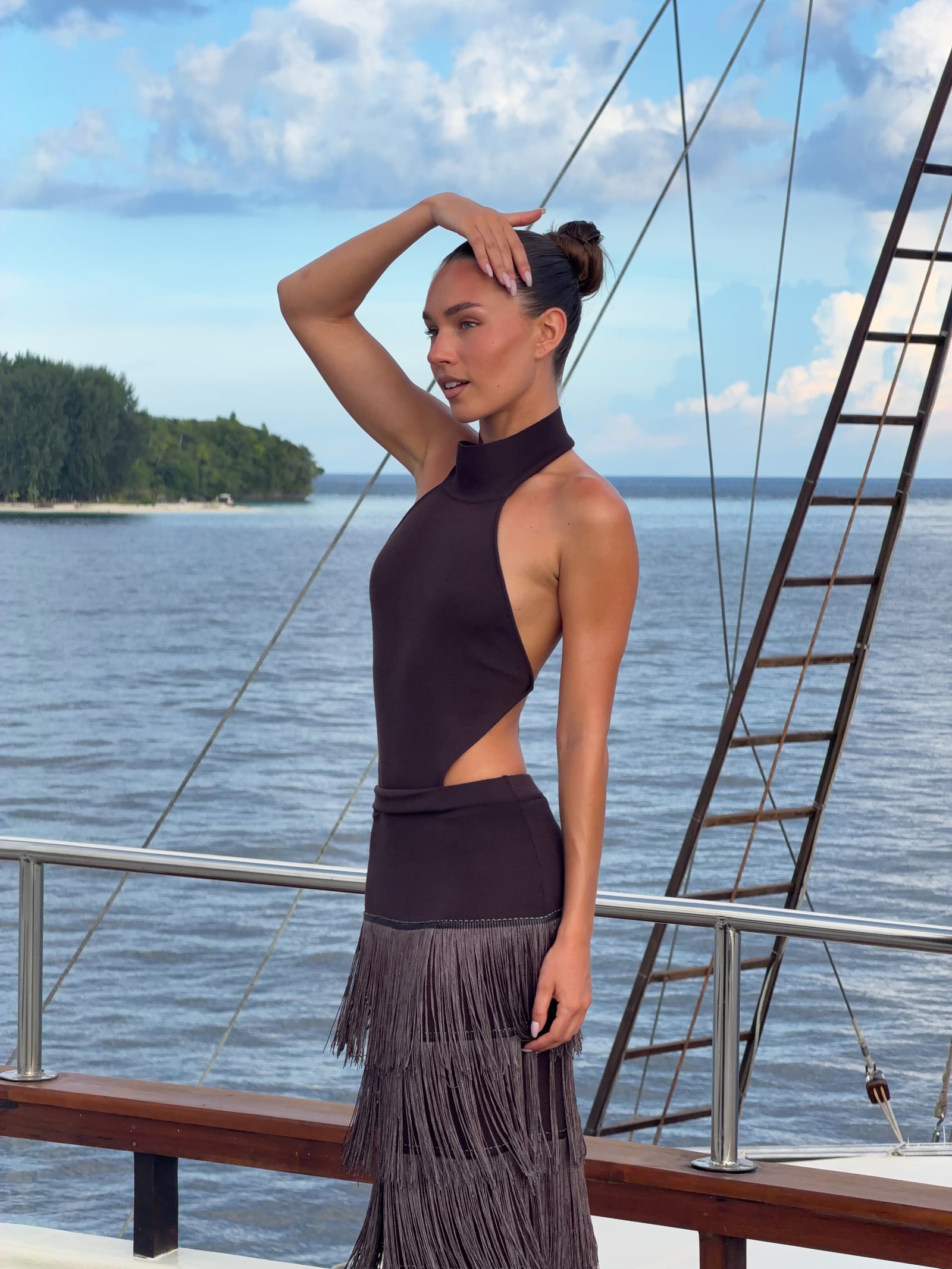 Three-quarter view of the Halter Fringe Maxi Dress emphasizing the high neckline and open waist