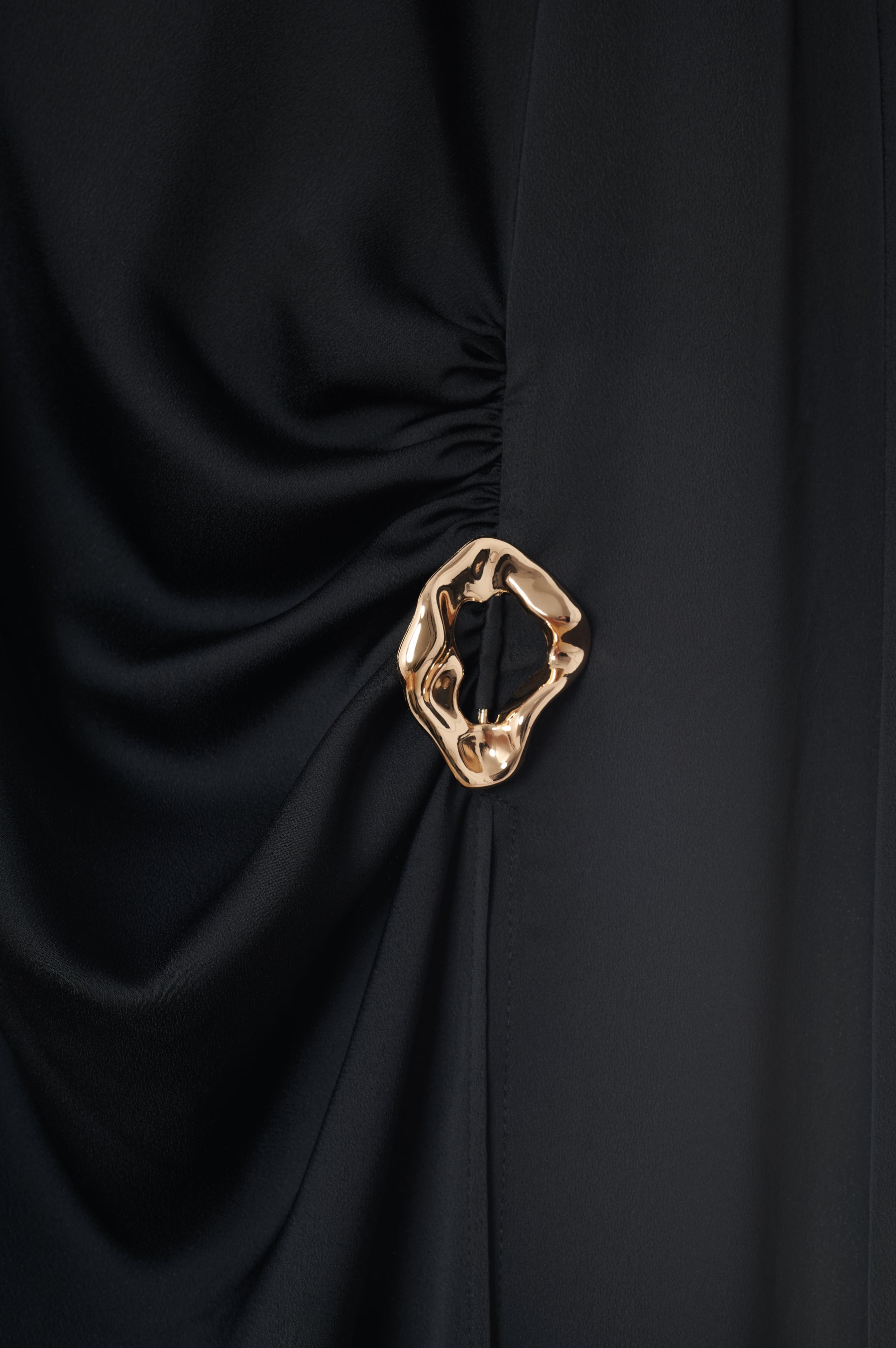 Thirteen distinct textile studies unified along one fine bronze axis